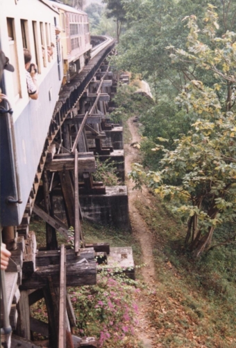 Rong ületab puidust silda Kwai jõe kaldal